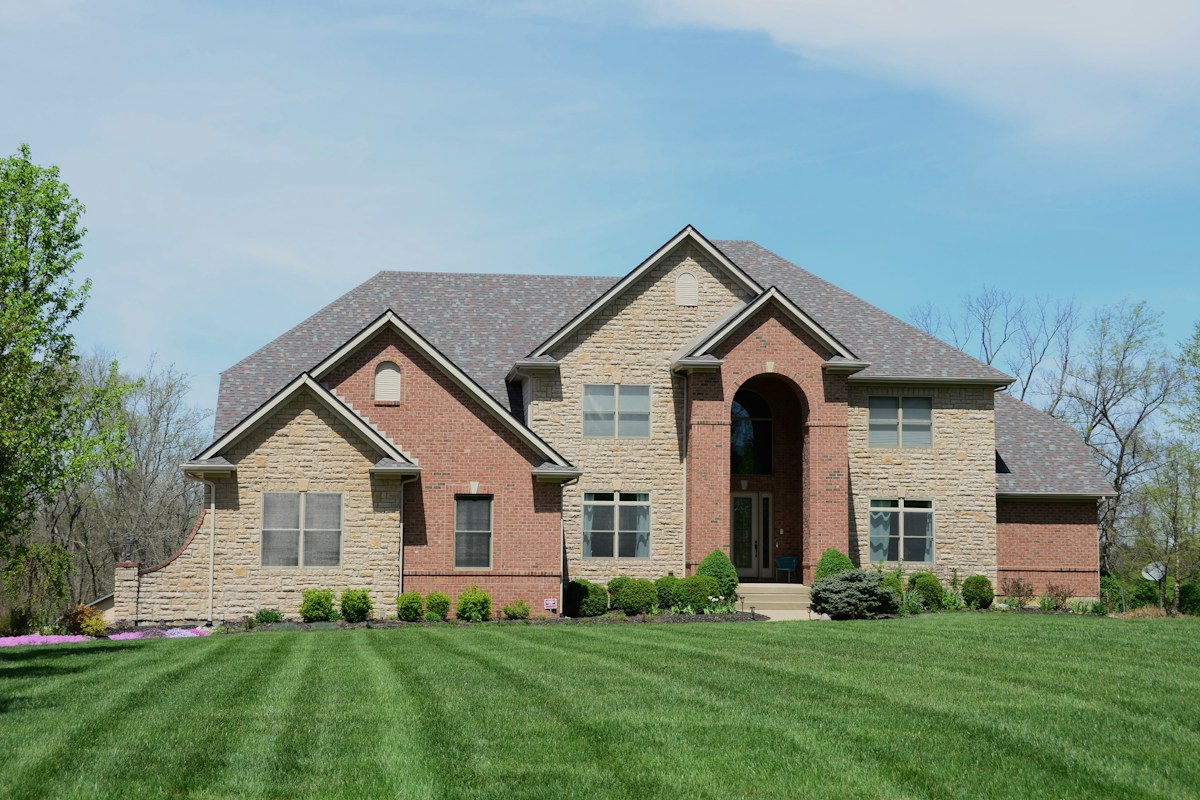 A brick house with a landscaped yard